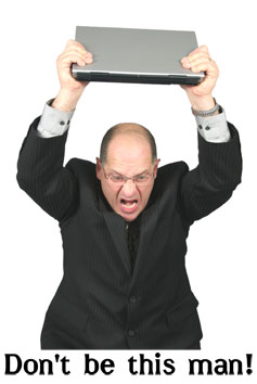 An apparently Angry Man about to throw a laptop into the floor